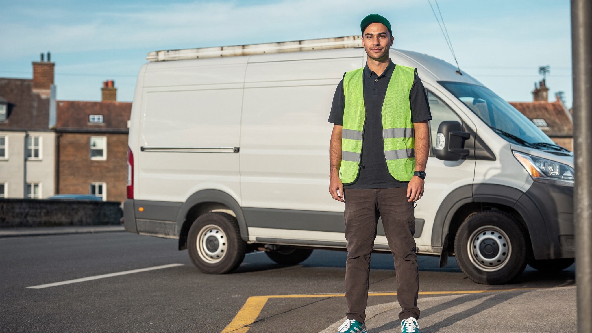 A UK courier beside a delivery van